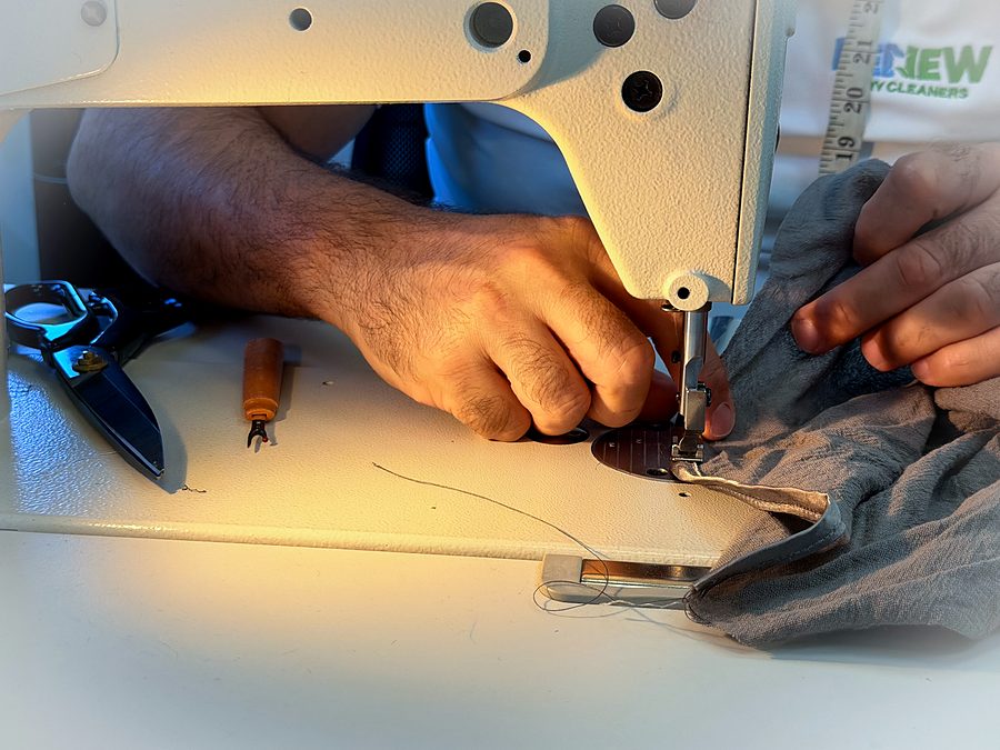 Our tailor guiding fabric under the needle of the industrial machine